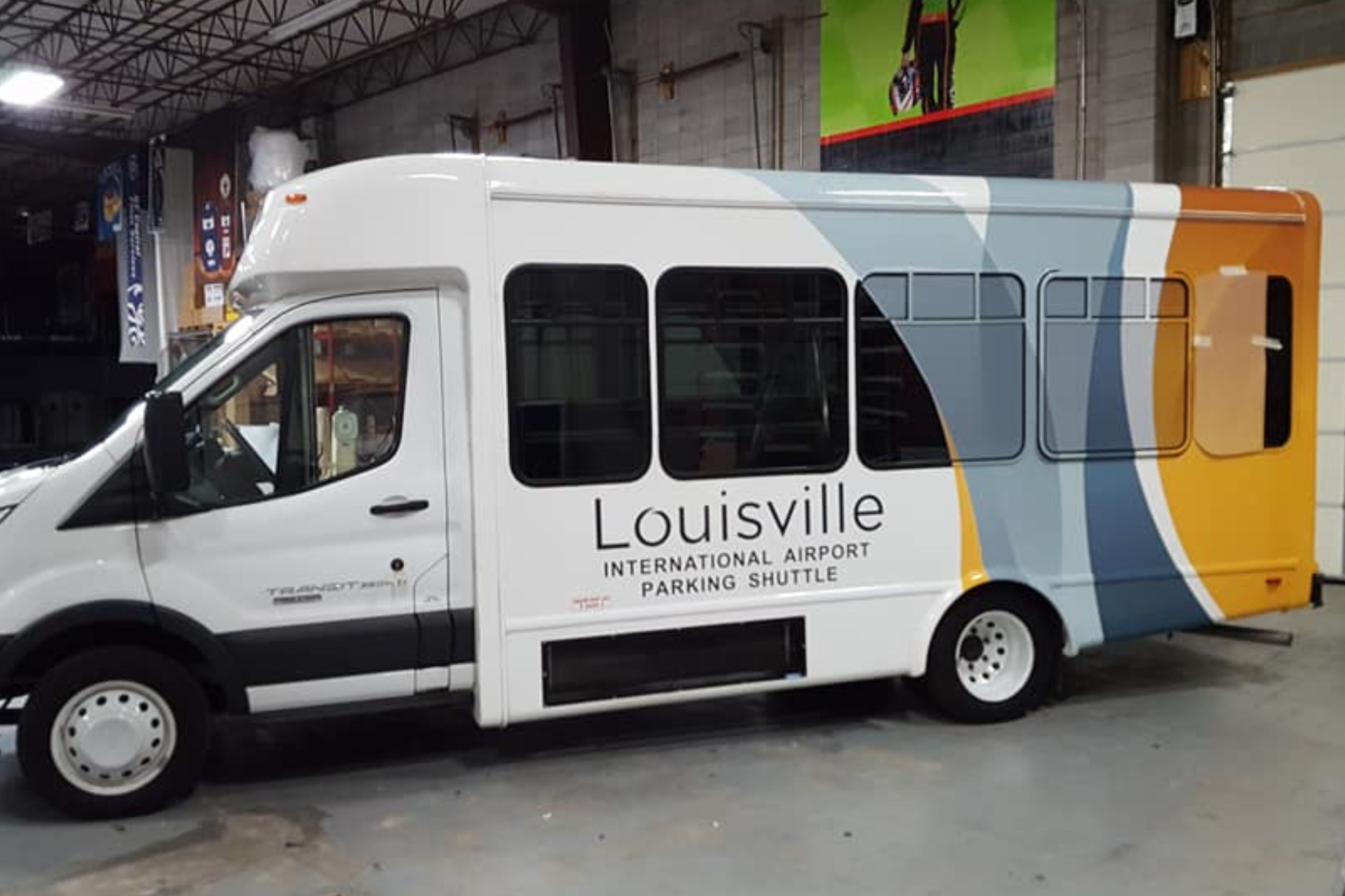 A Louisville-branded bus is stationed in a garage, highlighting its design and the secure environment of the parking area.